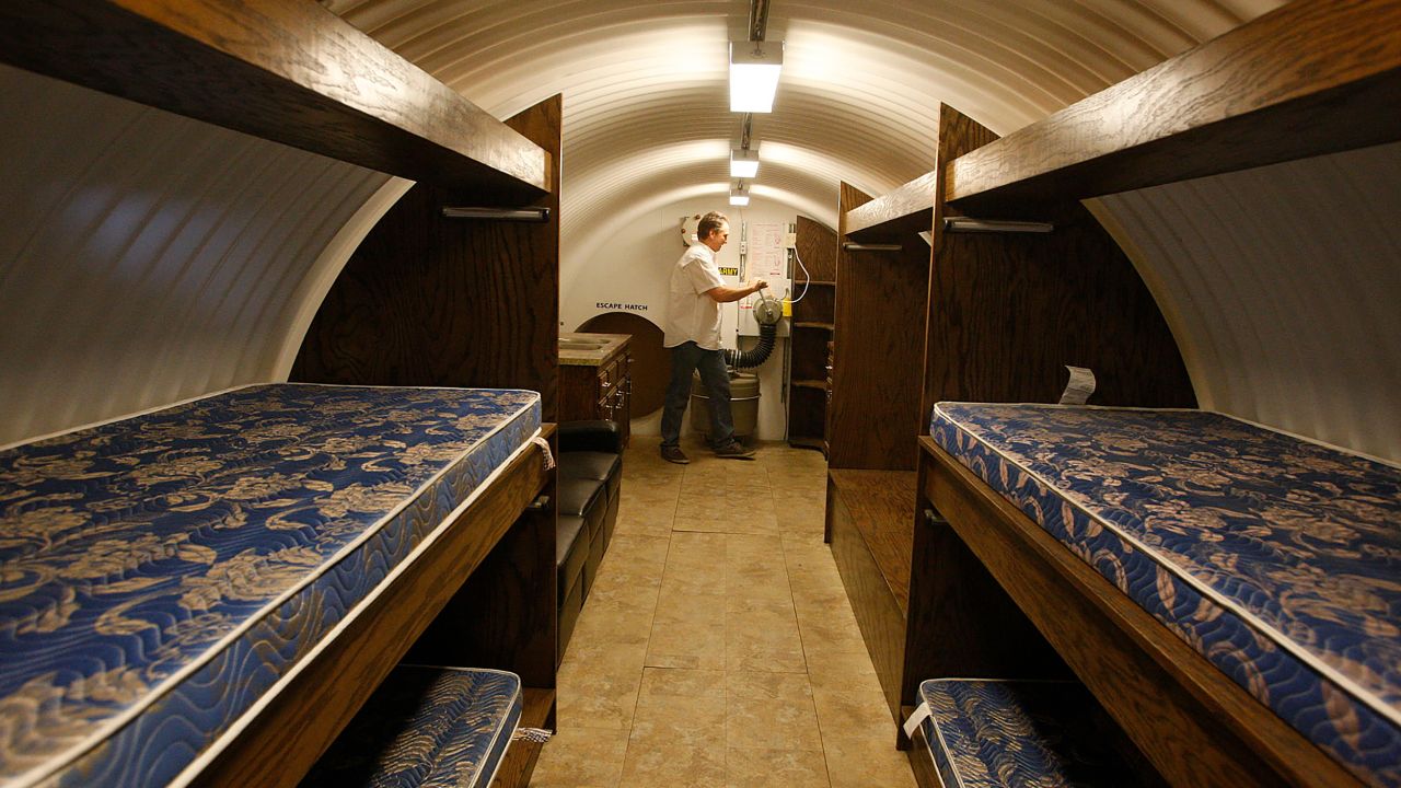 Some doomsdayers build underground bunkers. Ron Hubbard, CEO of Atlas Survival Bunkers, demonstrates how to manually pump air into a corrugated pipe bomb shelter.