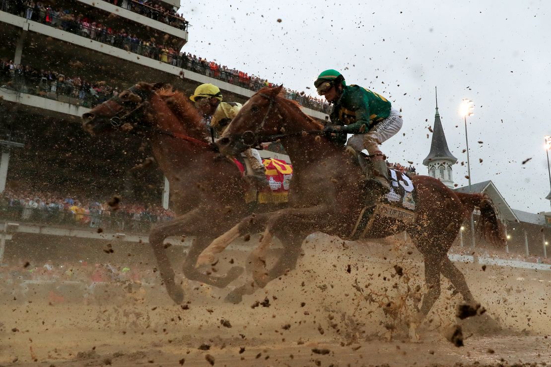Country House #20, ridden by jockey Flavien Prat, and Code of Honor #13, ridden by jockey John Velazquez, head to the first turn during 145th running of the Kentucky Derby.