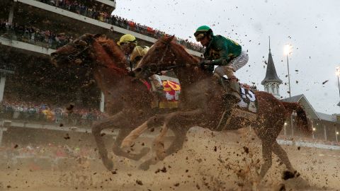 Country House #20, ridden by jockey Flavien Prat, and Code of Honor #13, ridden by jockey John Velazquez, head to the first turn during 145th running of the Kentucky Derby.