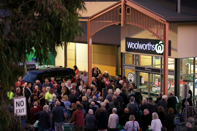 People wait outside a Woolworths store in Sunbury, Australia, on March 17, 2020. Australian supermarket chains announced special shopping hours for the elderly and people with disabilities so that they could shop in less crowded aisles.