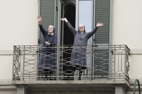 Two nuns greet neighbors from their balcony in Turin, Italy, on Sunday, March 15.
