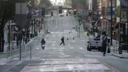 A man crosses a nearly empty street in San Francisco, Tuesday, March 17, 2020. Officials in seven San Francisco Bay Area counties have issued a shelter-in-place mandate affecting about 7 million people, including the city of San Francisco itself. The order says residents must stay inside and venture out only for necessities for three weeks starting Tuesday. (AP Photo/Jeff Chiu)