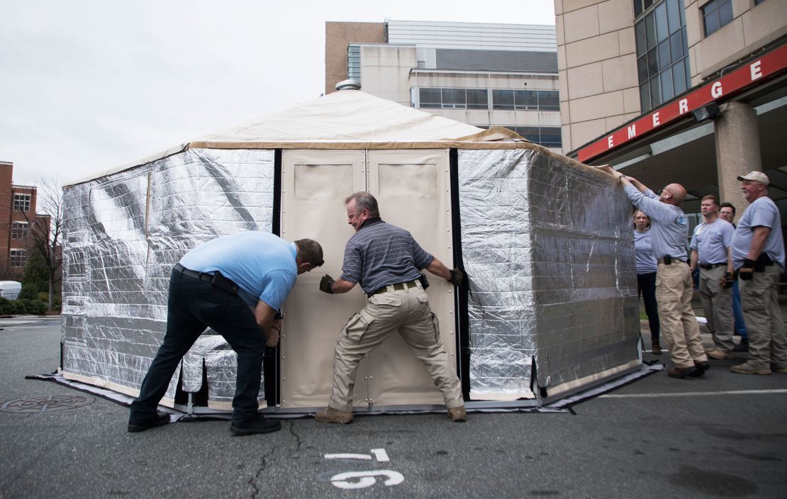 Members of the State Medical Assistance Team assemble a triage tent outside UNC Health's emergency department in Chapel Hill, North Carolina, to reduce pressure on the facility.