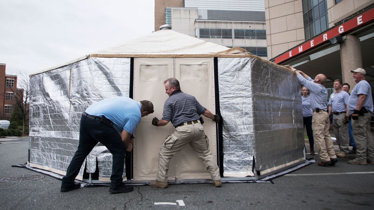 Members of the State Medical Assistance Team assemble a triage tent outside UNC Health's emergency department in Chapel Hill, North Carolina, to reduce pressure on the facility.