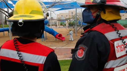 An Israeli firefighter sprays disinfectant in a children's playground in Modiin on Tuesday.