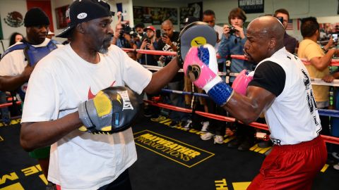 Floyd Mayweather Jr. (R) works out with his trainer and uncle Roger Mayweather at the Mayweather Boxing Club in 2014. 