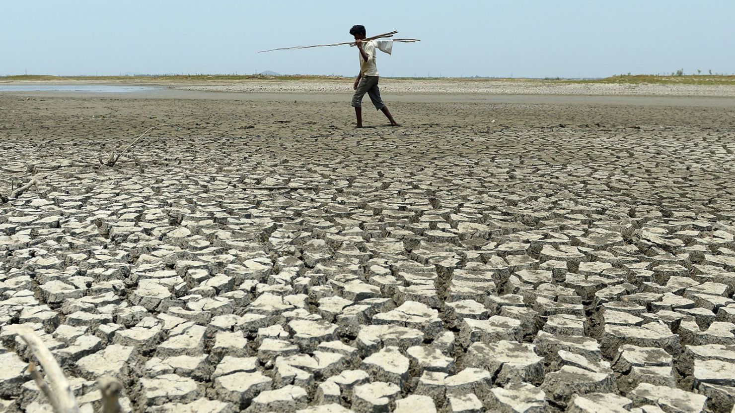 A man walks over the parched bed of a reservoir on the outskirts of Chennai, India.