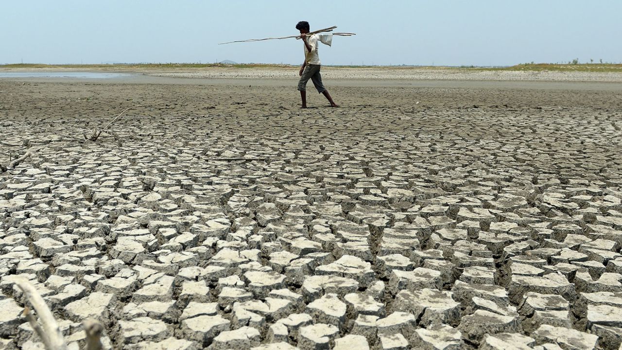 A man walks over the parched bed of a reservoir on the outskirts of Chennai, India.