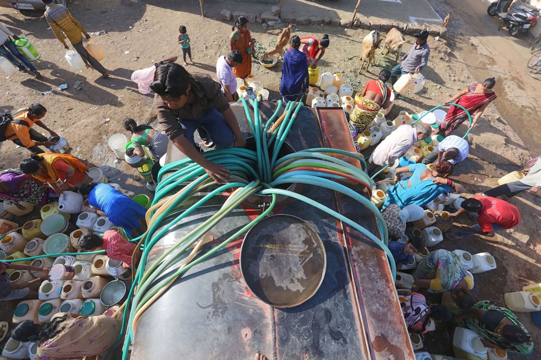 Indian slum dwellers collect potable water from a municipal water tanker in Durga Nagar.