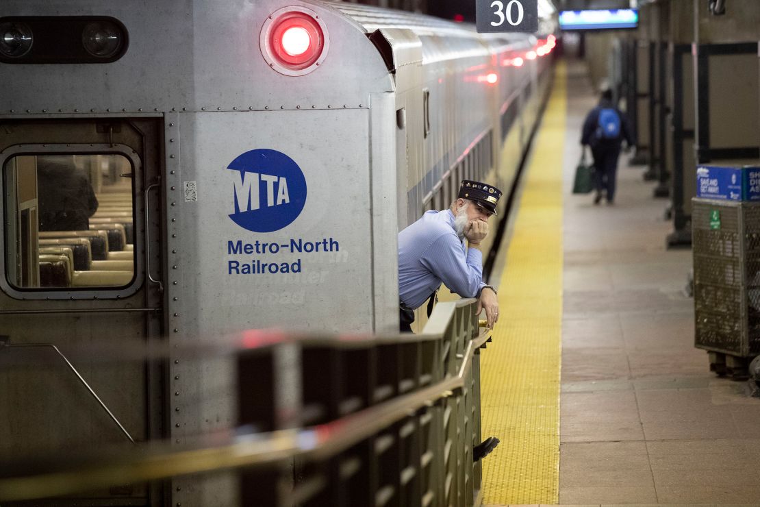 A conductor waits for customers to embark a train at Grand Central Terminal Tuesday.