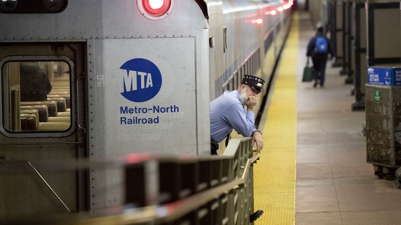 A conductor waits for customers to embark a train at Grand Central Terminal Tuesday.