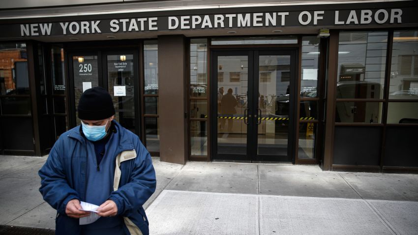 Visitors to the Department of Labor are turned away at the door by personnel due to closures over coronavirus concerns, Wednesday, March 18, 2020, in New York. Applications for jobless benefits are surging in some states as coronavirus concerns shake the U.S. economy. The sharp increase comes as governments have ordered millions of workers, students and shoppers to stay home as a precaution against spreading the virus that causes the COVID-19 disease.