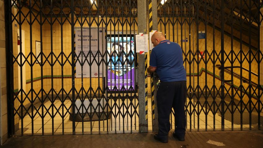 A TfL worker closes the gates at Barbican Underground station on March 19, 2020 as public transport services in London are reduced in an effort to delay the spread of the novel coronavirus.