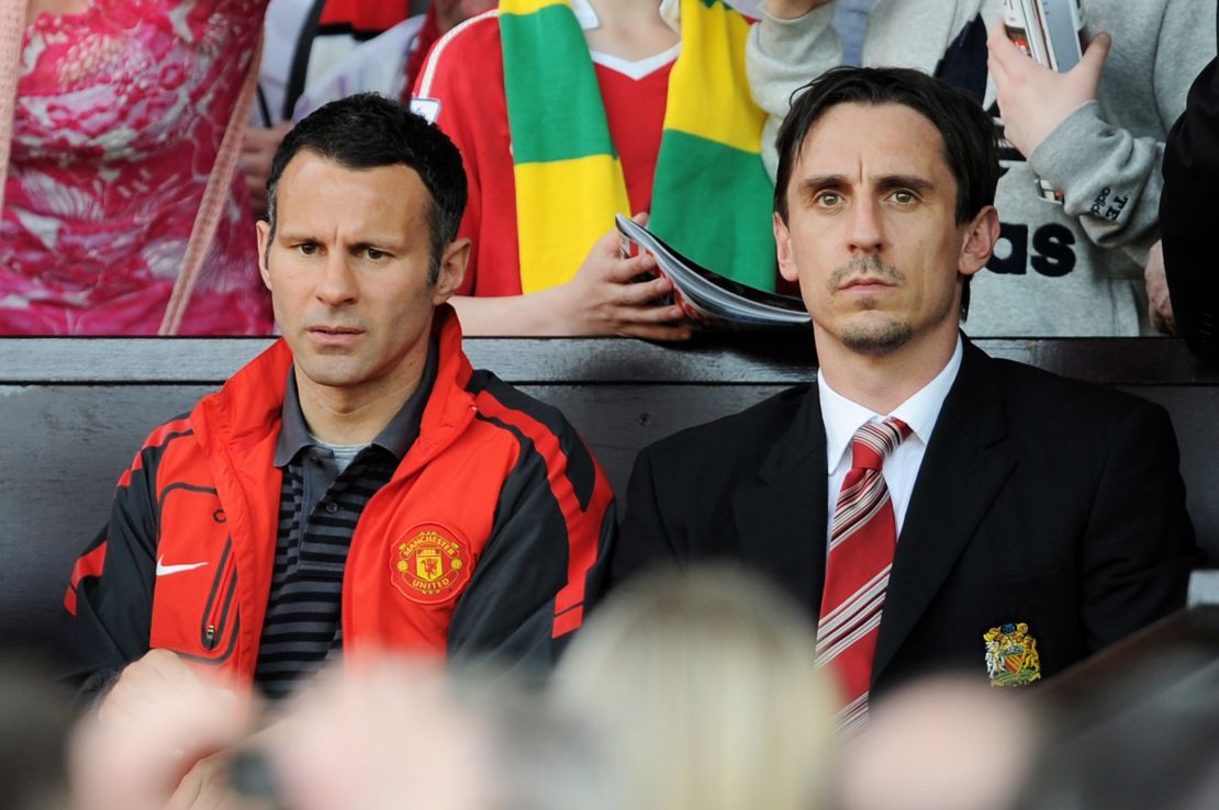 Giggs (left) and Neville (right) look on during the Premier League match between Manchester United and Fulham in 2011.