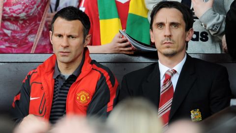 Giggs (left) and Neville (right) look on during the Premier League match between Manchester United and Fulham in 2011.