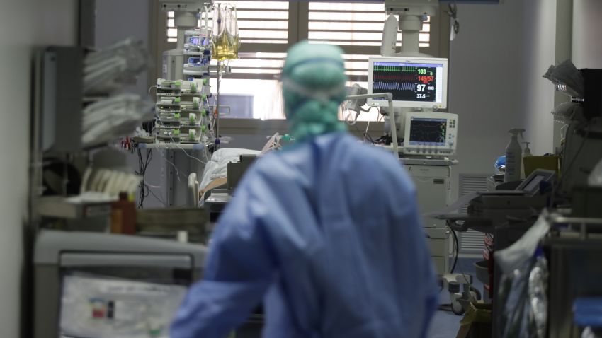 In this March 16, 2020, photo, a doctor watches a coronavirus patient under treatment in the intensive care unit of the Brescia hospital, Italy. Hospitals in northern Italy are struggling to make room for the onslaught of coronavirus patients. (AP Photo/Luca Bruno)