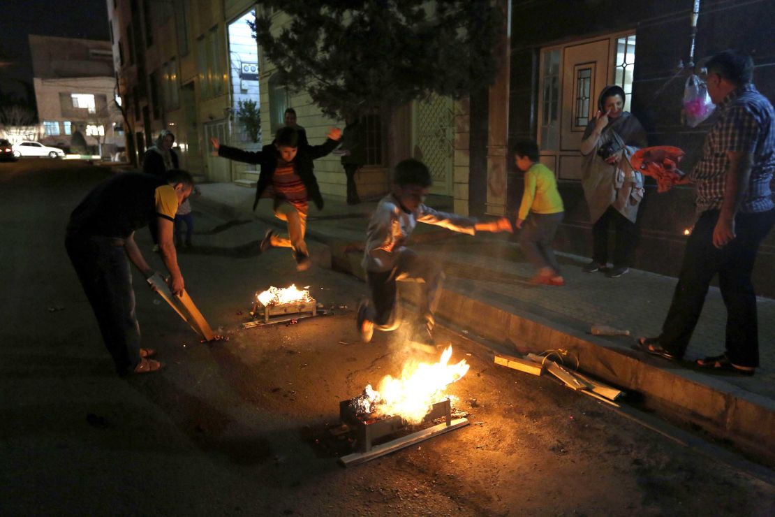 Iranian families light fire outside their houses in Tehran on March 13, 2018 during Chaharshanbe Soori.