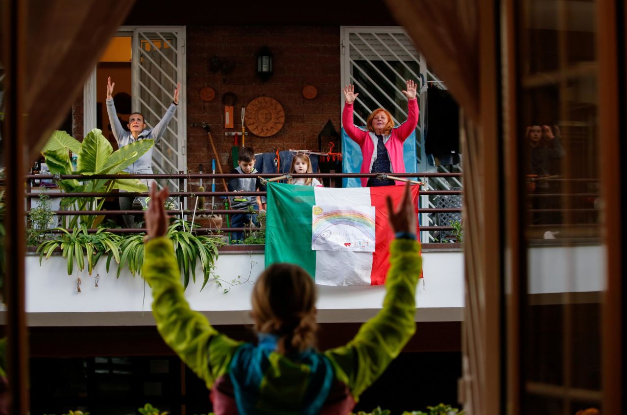 Personal trainer Antonietta Orsini, foreground, carries out an exercise class from her balcony in Rome on Wednesday, March 18. Italy has been on lockdown because of the coronavirus. <a href="https://www.cnn.com/interactive/2020/03/world/italy-family-coronavirus-lockdown-cnnphotos/index.html" target="_blank">Related story: What life is like on lockdown</a>