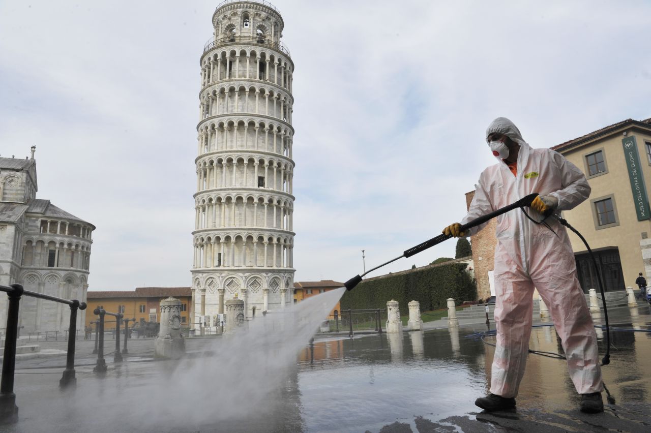 A worker sanitizes an area near Italy's Tower of Pisa on Tuesday, March 17.