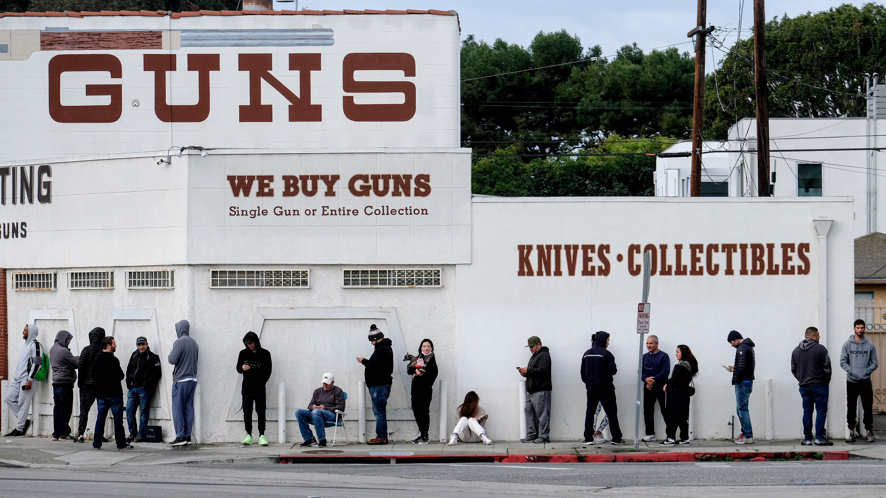People wait in a line to enter a gun store in Culver City, Calif., Sunday, March 15, 2020. Coronavirus concerns have led to consumer panic buying of grocery staples and now gun stores are seeing a similar run on weapons and ammunition as panic intensifies.
