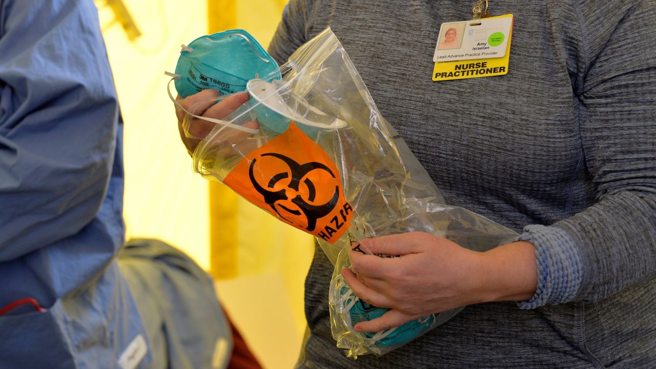 Hospital clinicians pass out masks to be put on before testing patients for the coronavirus, Covid-19 at Newton-Wellesley Hospital in Newton, Massachusetts on March 18, 2020, as the hospital has set up three tents in the parking garage where patients who have been pre-screened can show up for testing. - Since the virus first emerged in late December, 8,092 people have died around the world, with the global number of cases at 200,680, according to an AFP tally based on official sources as of 1300 GMT Wednesday. (Photo by Joseph Prezioso / AFP) (Photo by JOSEPH PREZIOSO/AFP via Getty Images)