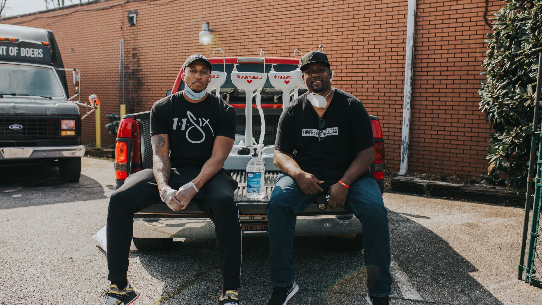 Hip hop artist Lecrae (left) and Love Beyond Walls founder Terence Lester (right) distribute portable wash stations around Atlanta.