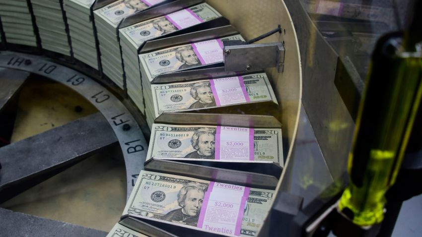 Packs of freshly printed 20 USD notes are processed for bundling and packaging at the US Treasury's Bureau of Engraving and Printing in Washington, DC July 20, 2018. - The dollar slid against the euro and pound on Friday, July 20, 2018, as US President Donald Trump adopted an aggressive posture on trade and foreign exchange, stoking talk of a currency war in addition to a trade war.