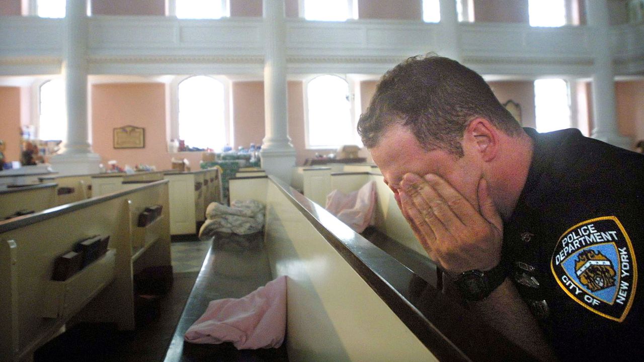 An NYPD officer rubbed his eyes after napping on a pew at St. Paul's Chapel near the site of the World Trade Center attack in 2001. 