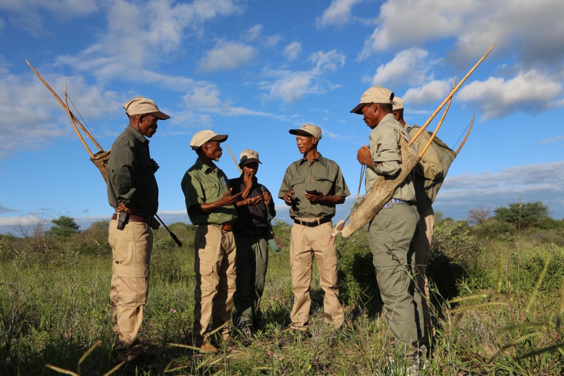 San trackers in the Kalahari discussing animal prints. 