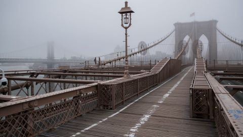Fog envelops the Manhattan skyline as the Brooklyn Bridge sits nearly empty of pedestrian traffic on Friday. 