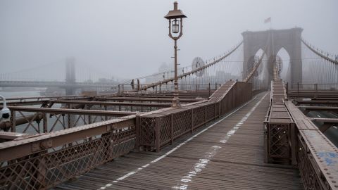 Fog envelops the Manhattan skyline as the Brooklyn Bridge sits nearly empty of pedestrian traffic on Friday.