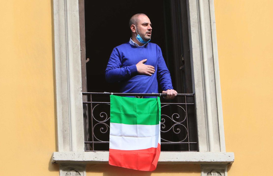 A resident appears at his window, singing the national anthem. 