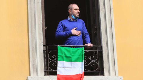 A resident appears at his window, singing the national anthem. 