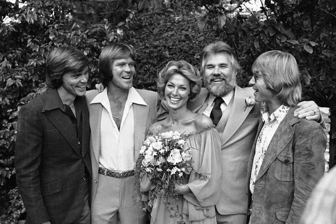 Rogers poses for a photo on his wedding day in 1977. From left: John Davidson, Glen Campbell, bride Marianne Gordon, Rogers and John Denver.