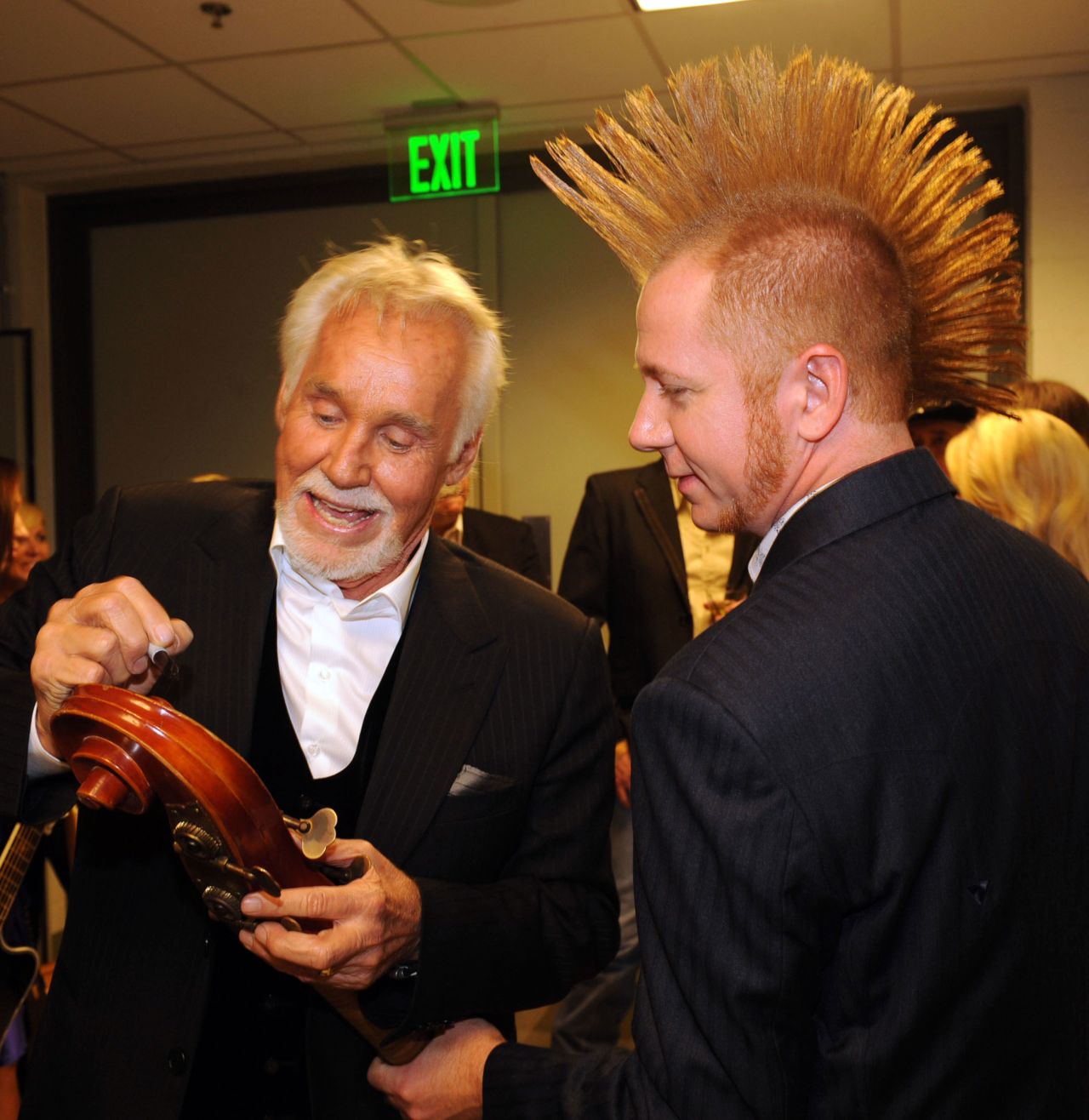 Rogers gives an autograph to musician Aden Bubeck backstage during the ACM Honors in Nashville in 2009.