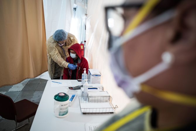 A doctor examines Juan Vasquez inside a testing tent at St. Barnabas Hospital in New York.