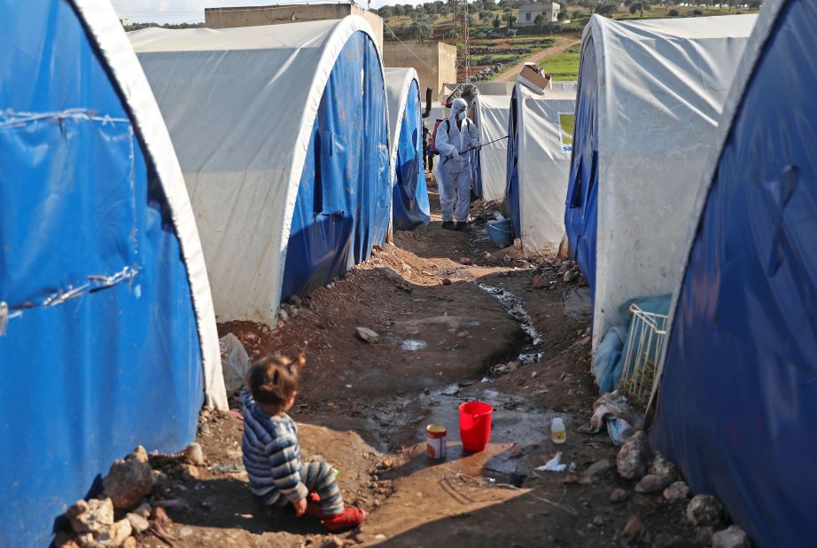 A member of the Syrian Violet relief group disinfects tents at a camp for displaced people in Kafr Jalis, Syria, on March 21, 2020.