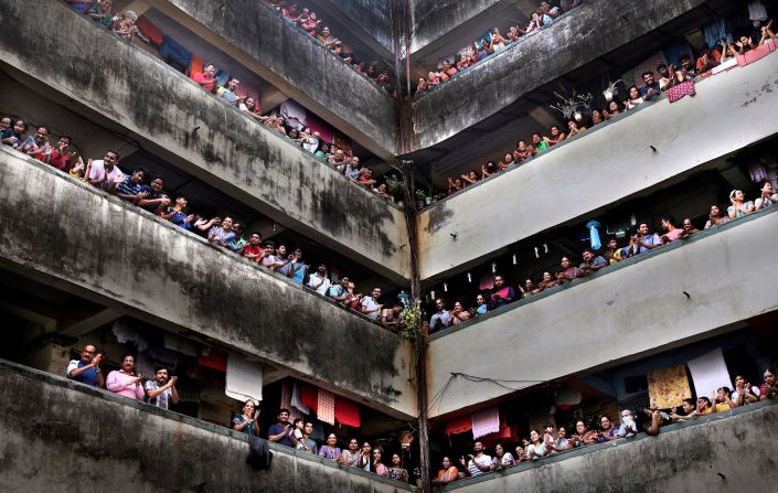 People clap from balconies to show their appreciation for health care workers in Mumbai, India.