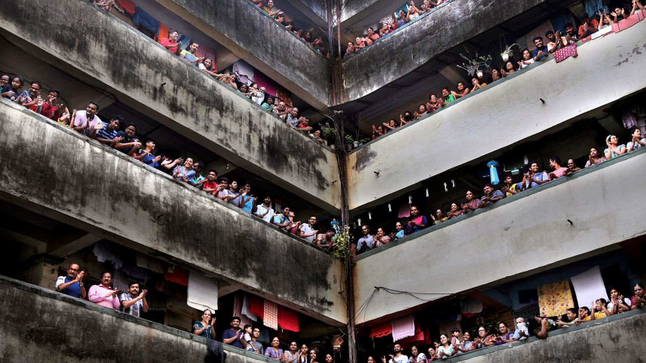 People clap from balconies at a chawl in Mumbai on Sunday. 