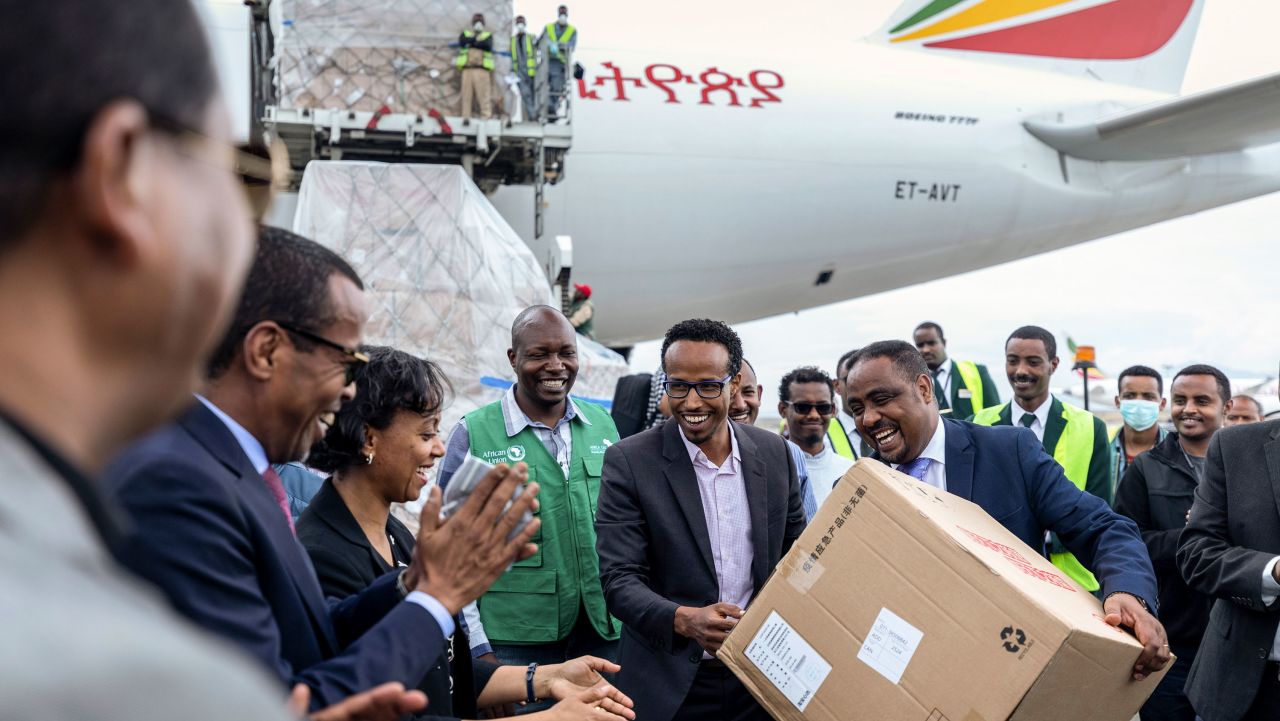 National Coordinator Dr Shumete Gizaw, center-right, hands over a box of medical supplies to Minister of Health Dr Lia Tadesse, center-left, after a cargo flight containing over 6 million medical items including face masks, test kits, face shields and protective suits arrived in the capital Addis Ababa, Ethiopia Sunday, March 22, 2020. The supplies arriving from Guangzhou, China for fighting the spread in Africa of the COVID-19 coronavirus were donated by the Jack Ma Foundation and Alibaba Foundation and will be distributed from Ethiopia to countries throughout Africa.(AP Photo/Mulugeta Ayene)