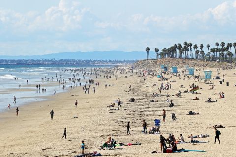 People are seen on California's Huntington Beach on March 21, 2020. Crowds descended on California beaches, hiking trails and parks over the weekend in open defiance of a state order to shelter in place and avoid close contact with others.