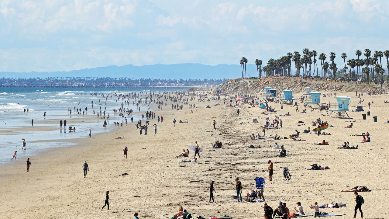 People are seen on the beach on March 21, 2020 in Huntington Beach, California. 