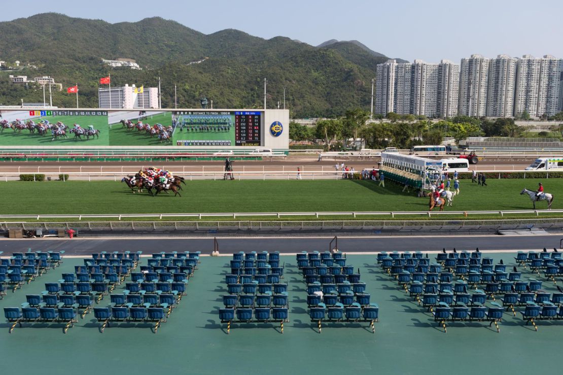 Horses gallop past the empty public stands at Sha Tin Racecourse.