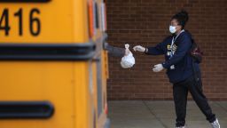 GAITHERSBURG, MARYLAND - MARCH 20: Montgomery County Public Schools Special Needs Bus Attendant Zanashia Rowe helps distribute bags of food donated by Manna Food Center at Quince Orchard High School as part of a program to feed children while schools are closed due to the coronavirus March 20, 2020 in Gaithersburg, Maryland. Millions of children across the country rely on meals they get at school, which are closed in an attempt to suppress transmission of the COVID-19 virus. (Photo by Chip Somodevilla/Getty Images)