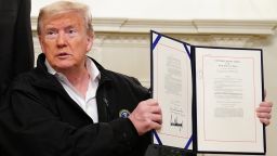 US President Donald Trump holds up an USD 8 billion emergency funding bill to combat COVID-19, coronavirus, after signing it in the Diplomatic Room of the White House in Washington, DC on March 6, 2020. (Photo by MANDEL NGAN / AFP) (Photo by MANDEL NGAN/AFP via Getty Images)