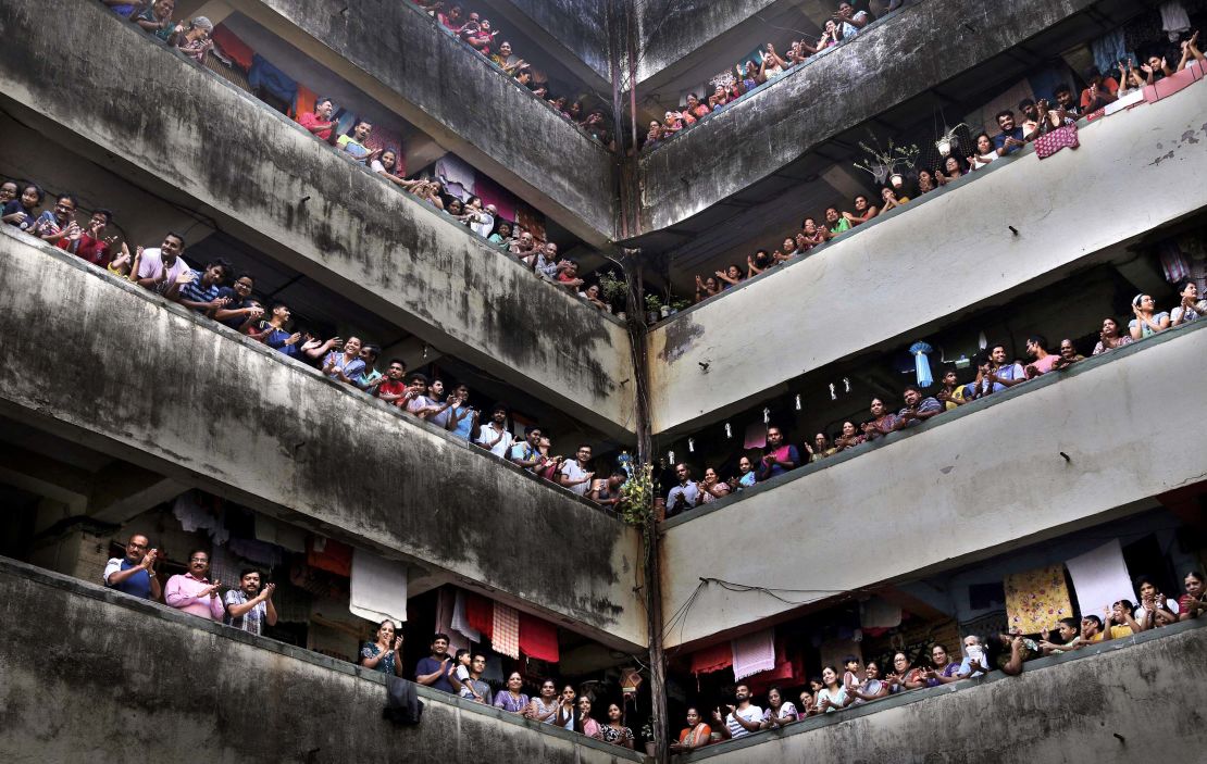 People clap from balconies in show of appreciation to health care workers in Mumbai, India on March 22, 2020.