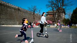 Children wearing facemasks amid concerns over the spread of the COVID-19 novel coronavirus, play at a park in Beijing on March 20, 2020. (Photo by WANG ZHAO / AFP) (Photo by WANG ZHAO/AFP via Getty Images)