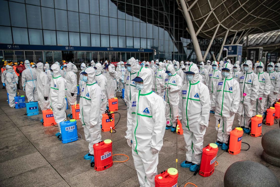 Staff members line up as they prepare to disinfect Wuhan Railway Station on Tuesday, March 24.