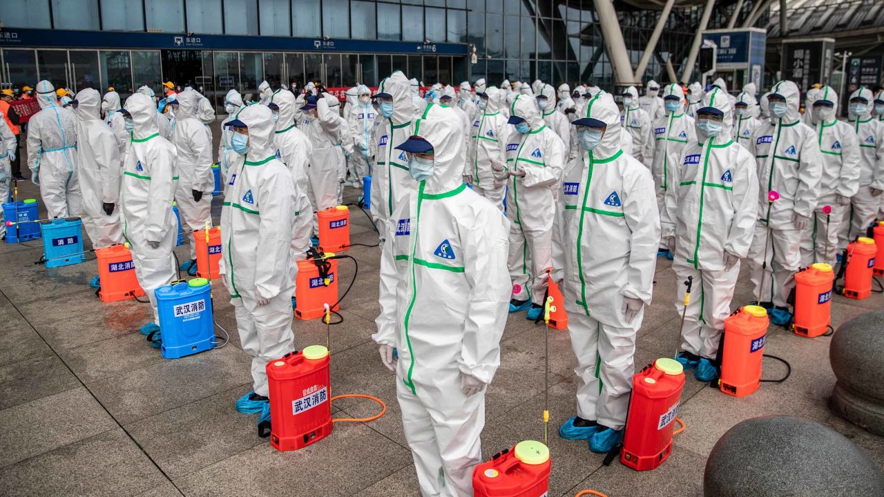 Staff members line up as they prepare to disinfect Wuhan Railway Station on Tuesday, March 24.