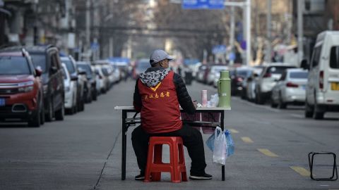 A volunteer guards a temporary wall blocking a road in Wuhan on March 12.
